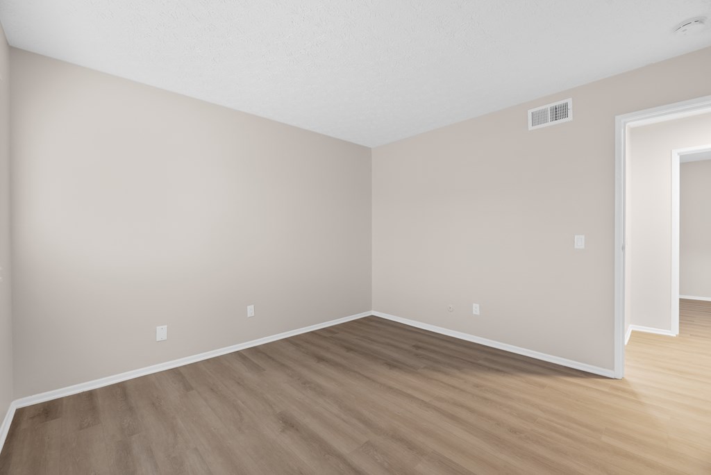 A room with wooden flooring and a white ceiling.