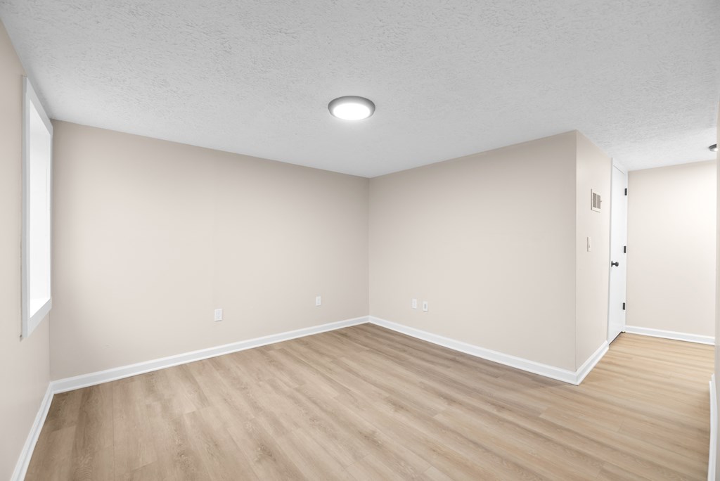 A room with wooden flooring and a ceiling light.