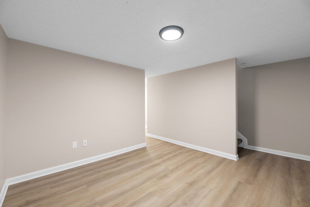 A room with wooden flooring and white walls.