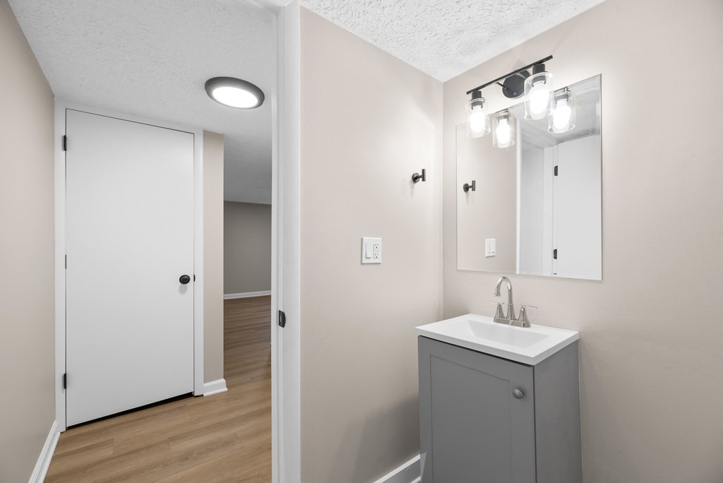 A bathroom with a white sink and a white door.