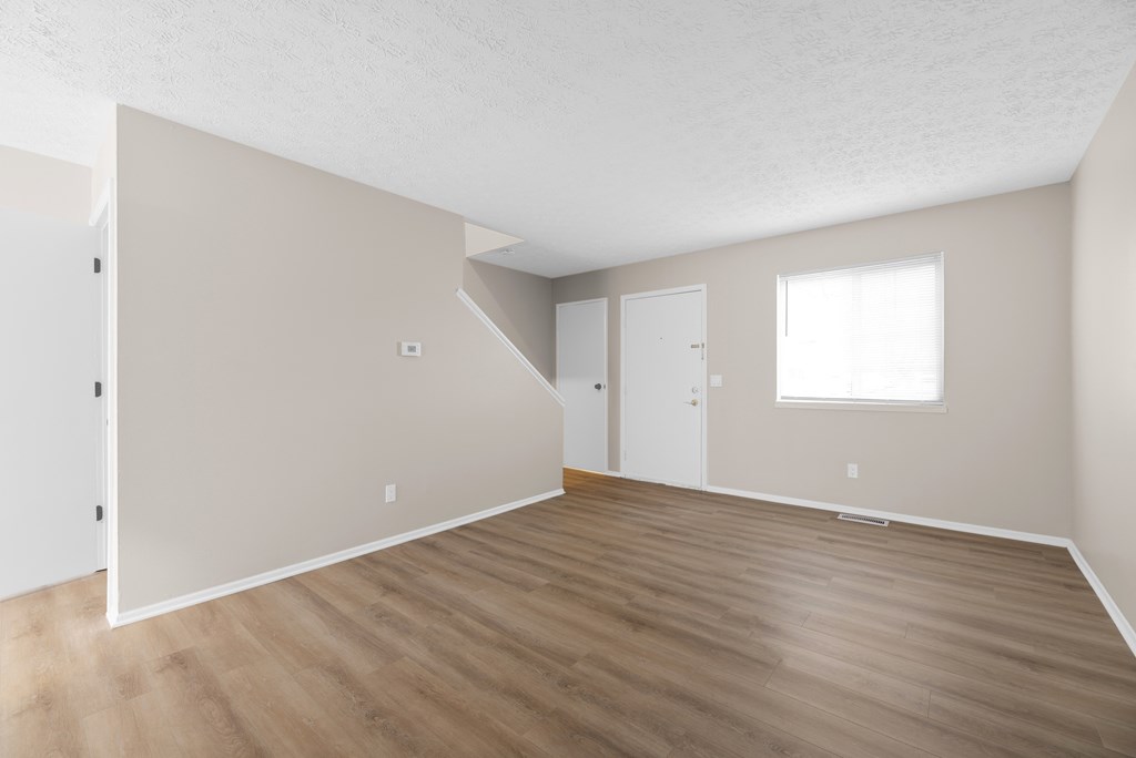 Empty room with wooden floors and white walls.