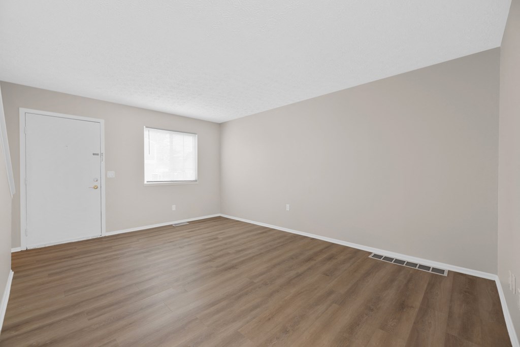 Empty room with wooden floor and white walls.