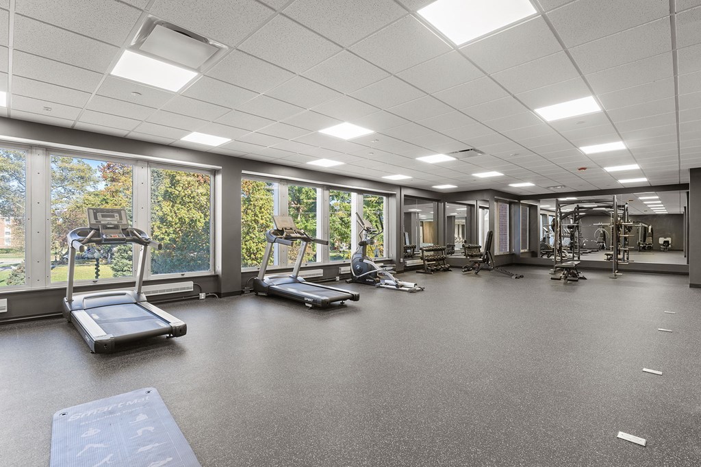 A spacious gym with treadmills, exercise bikes, and other equipment.