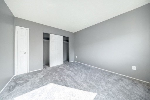 a bedroom with grey walls and white carpet