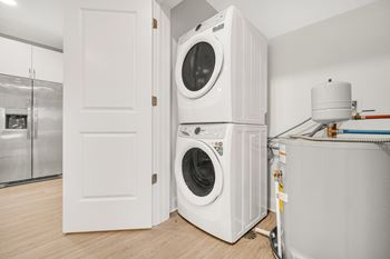 A white washing machine is in a small room. at Park Lamont Townhomes Apartments, Cleveland
