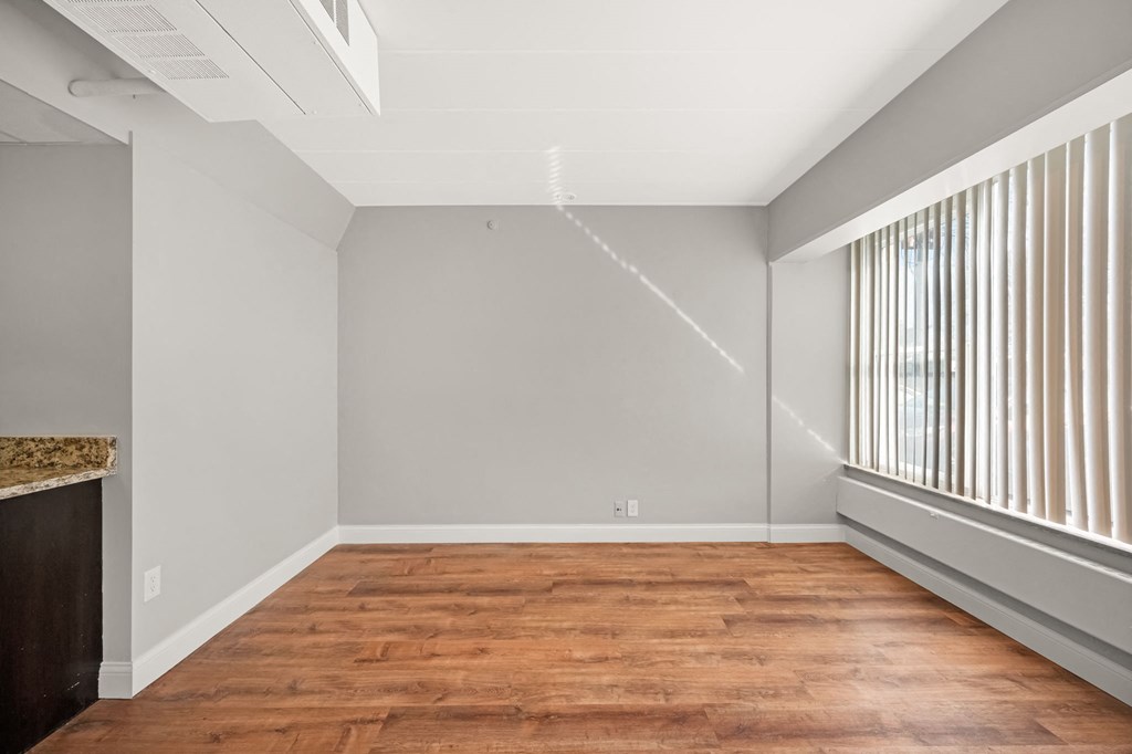 an empty living room with wood flooring and a large window