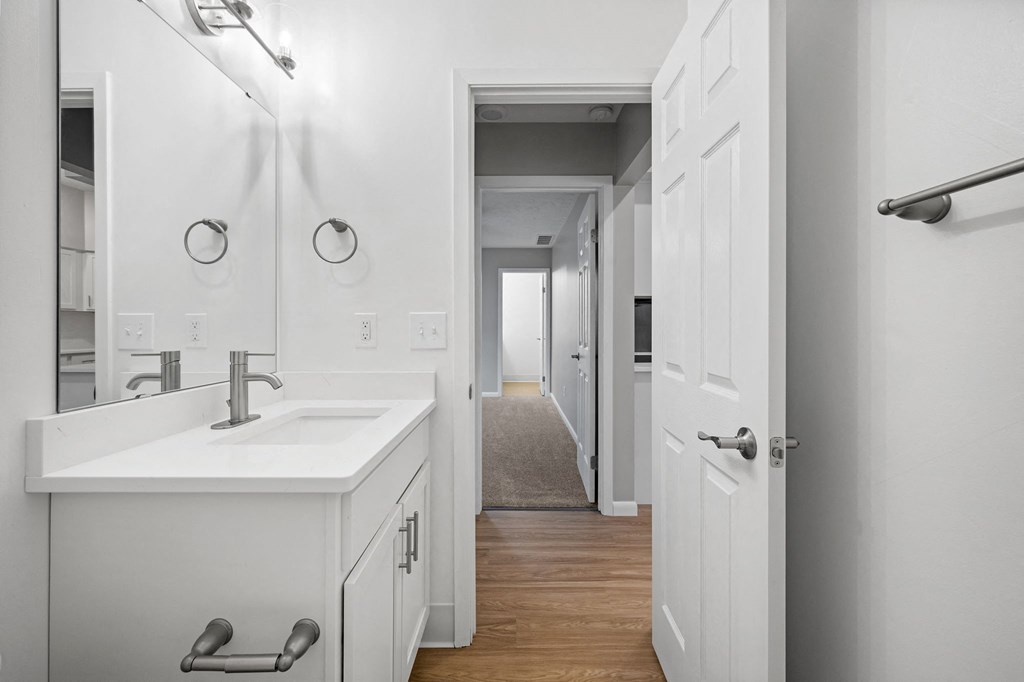 a white bathroom with a sink and a mirror