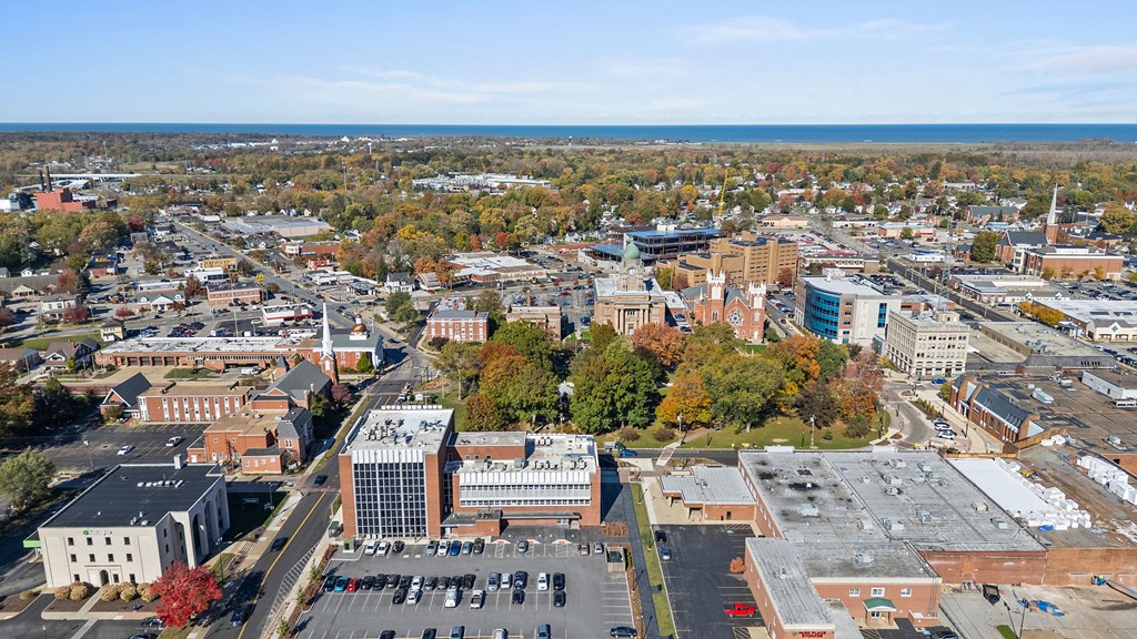 A cityscape with buildings and a parking lot.