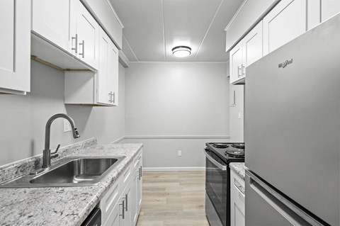 the kitchen in a new home with white cabinets and granite counter tops