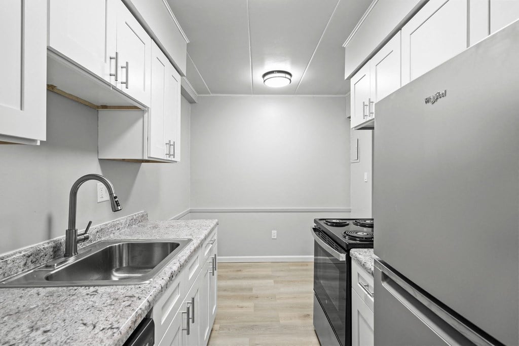 the kitchen in a new home with white cabinets and granite counter tops