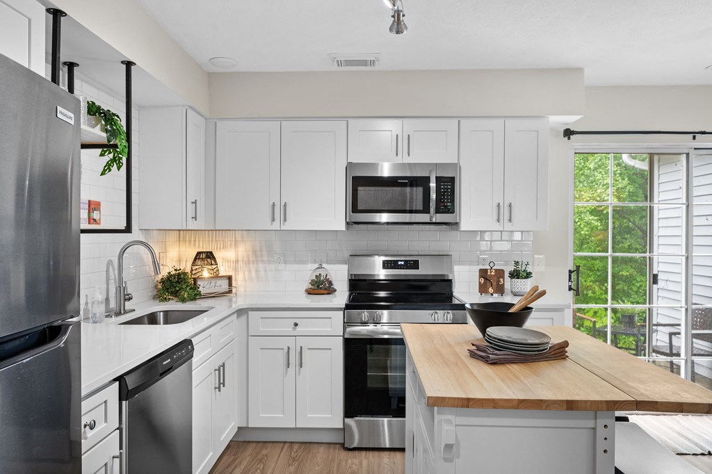 a kitchen with white cabinets and black appliances
