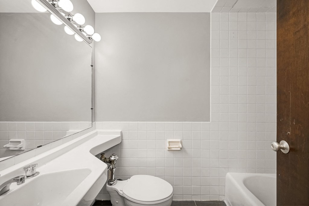 a white bathroom with a white toilet and a sink