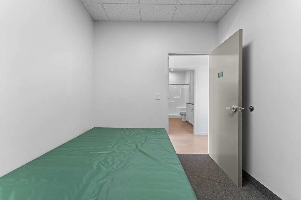 A room with a bed and a door.