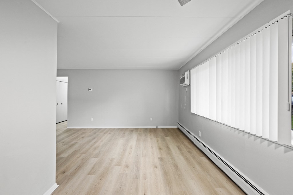 an empty living room with white walls and wooden floors