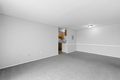 A room with white walls and a grey carpet.