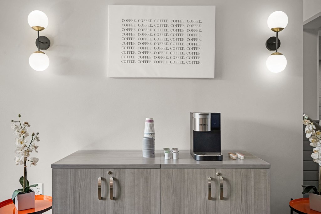 a cupboard with a coffee maker and a tablet on it in a living room