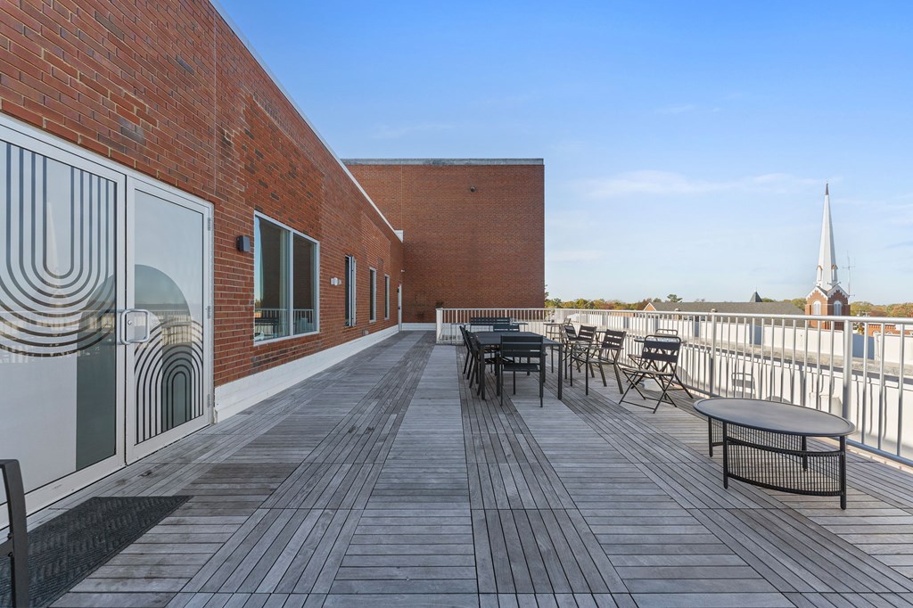 A wooden deck with chairs and a table.