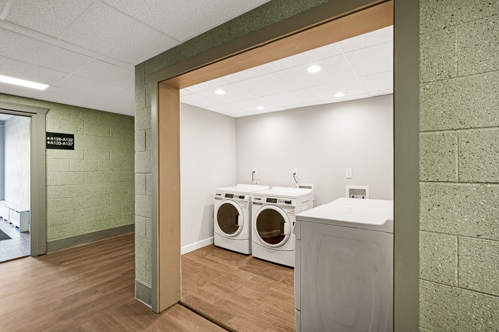 a washer and dryer in a laundry room with a counter and a door