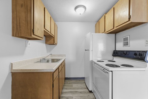 A kitchen with a white stove and wooden cabinets.