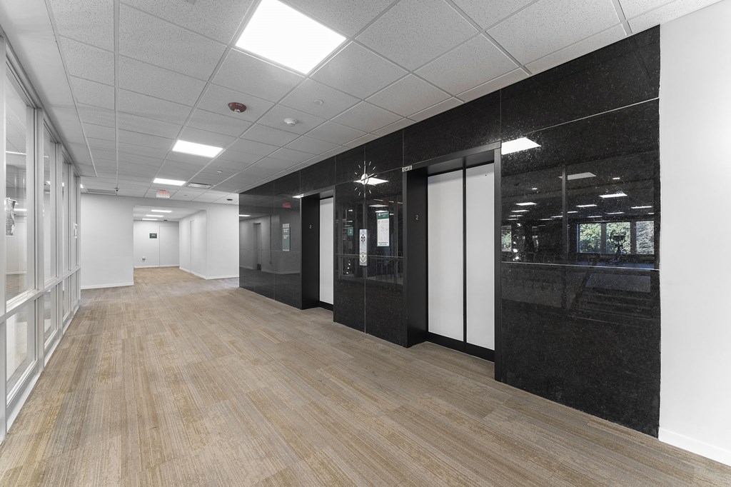 A long hallway with wood floors and white walls.