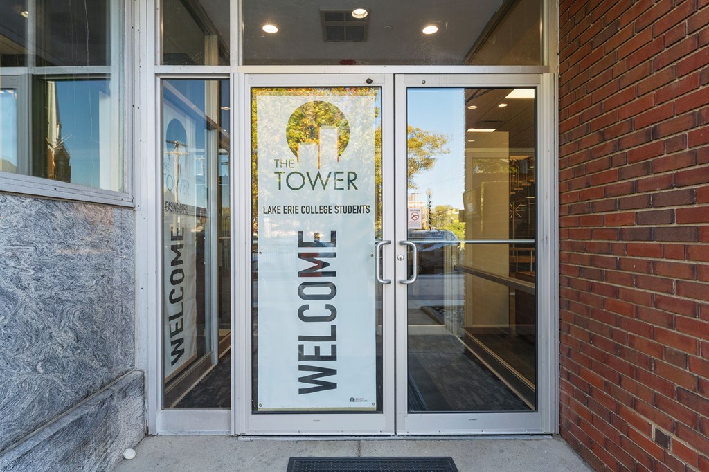 The entrance to a building with a glass door and a sign that says