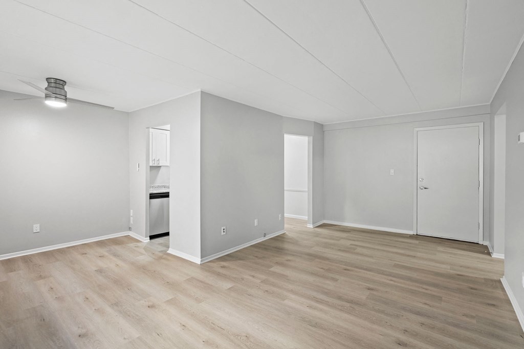 an empty living room with white walls and wood flooring