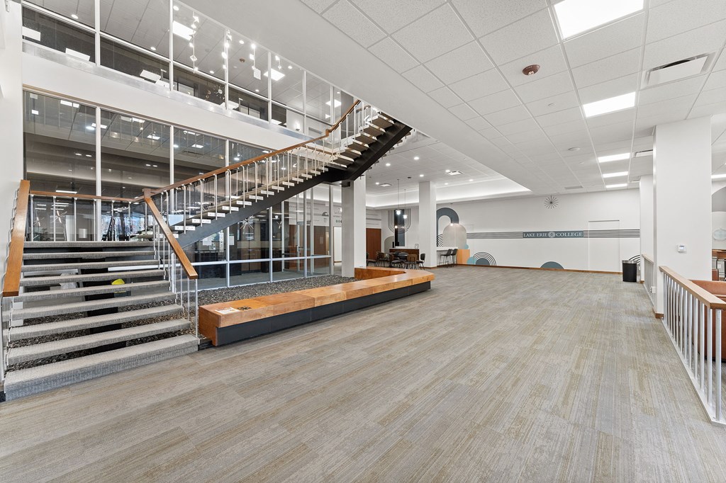 A spacious room with a staircase and a bench.