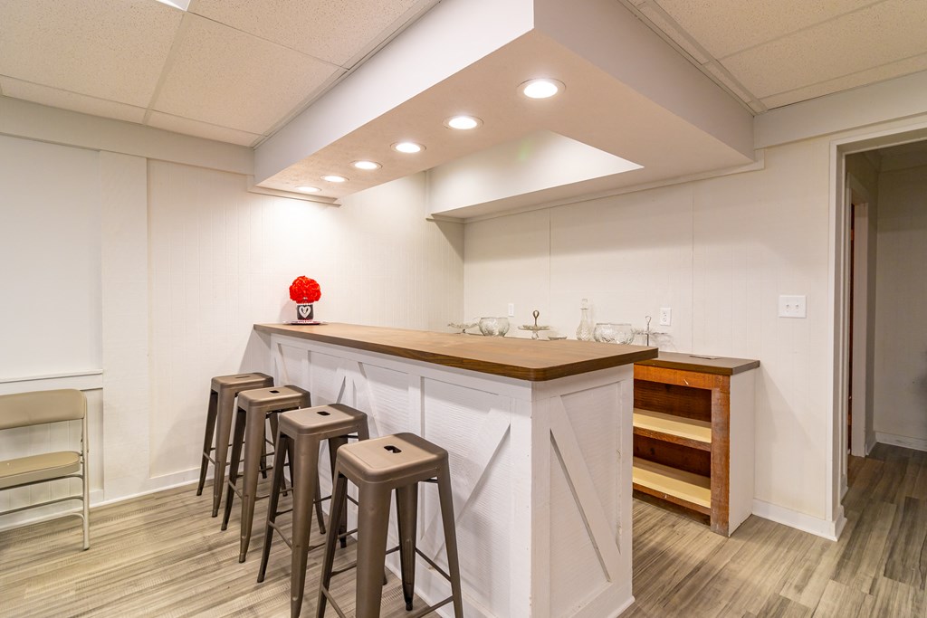 a bar with four stools in front of a counter in a room