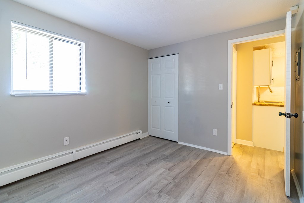 an empty living room with a door and a window