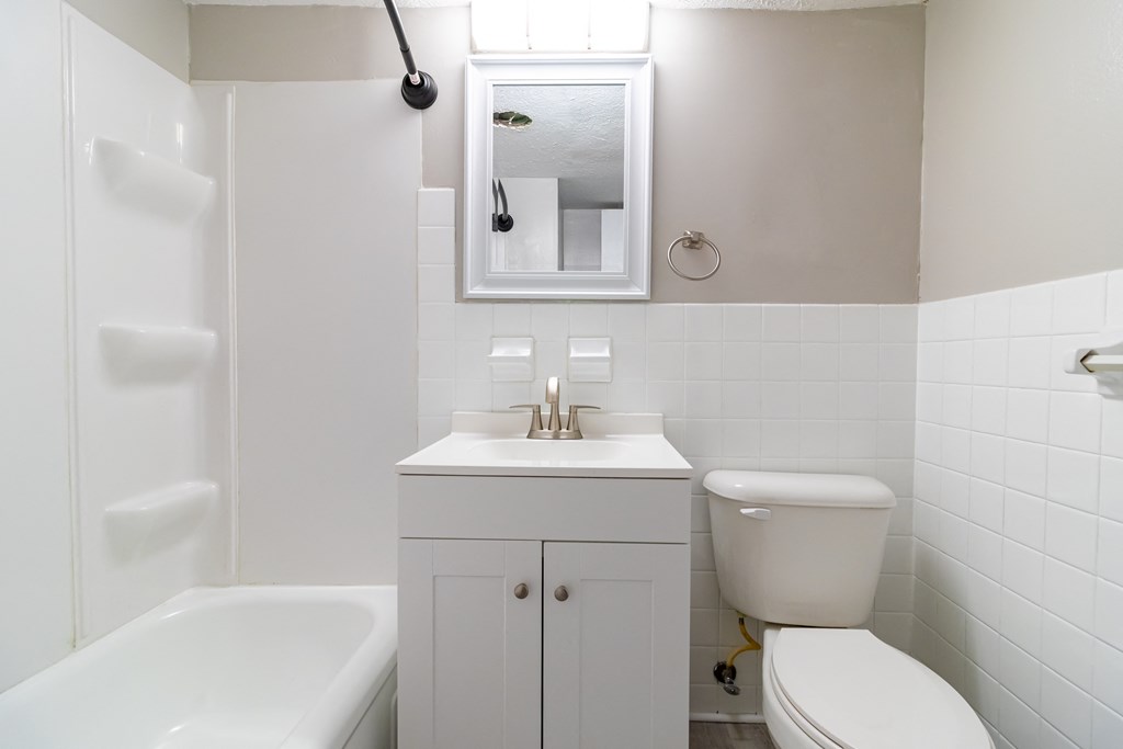 a white bathroom with a sink toilet and a bath tub