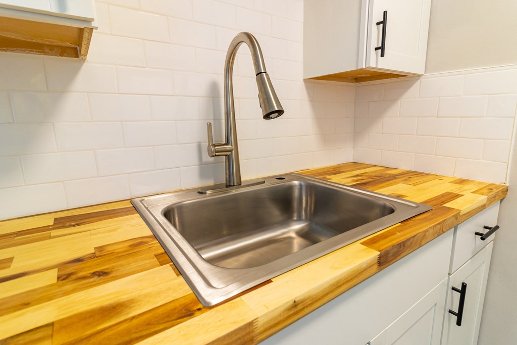a stainless steel sink in a kitchen with wooden counter tops