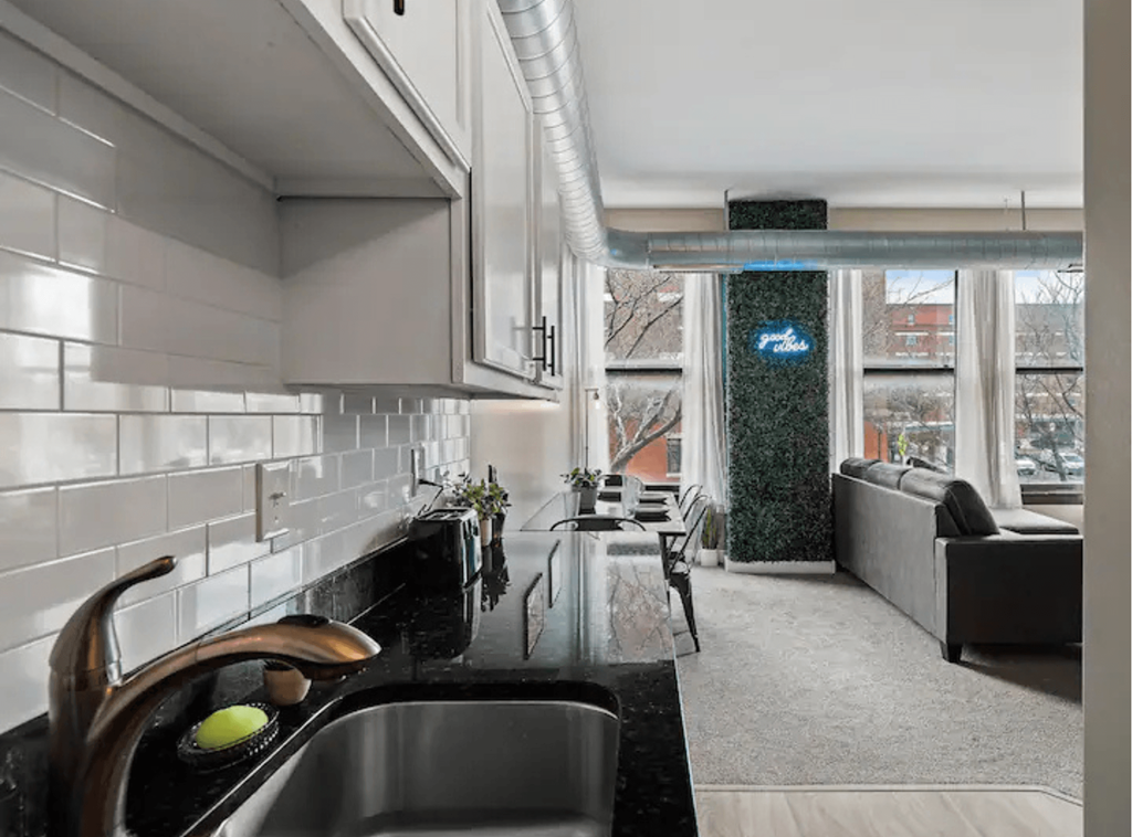 a kitchen and living room with a sink and a window