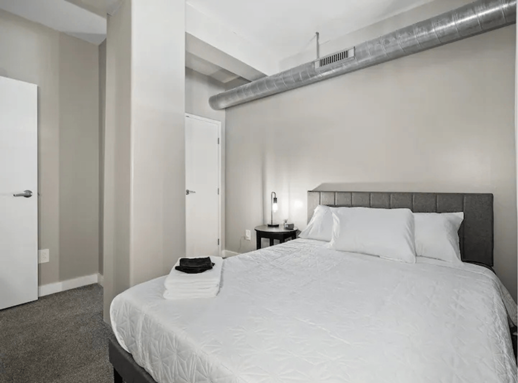 a white bedroom with a large bed and a white closet