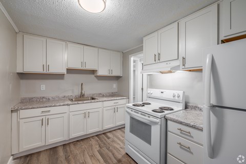 A kitchen with white appliances and cabinets.