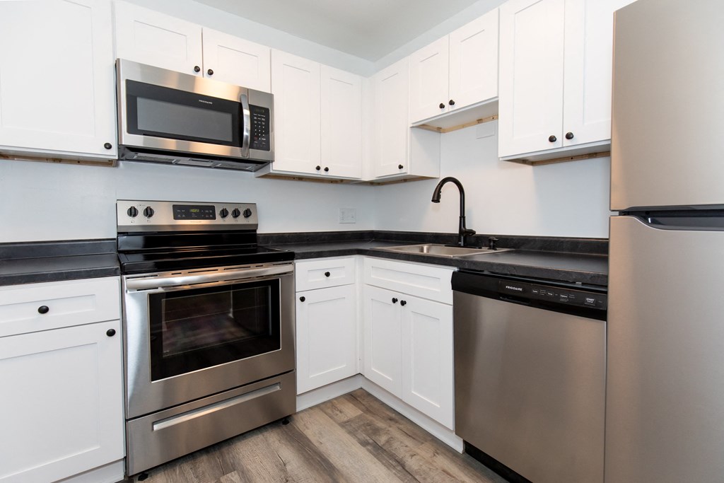 a kitchen with stainless steel appliances and white cabinets