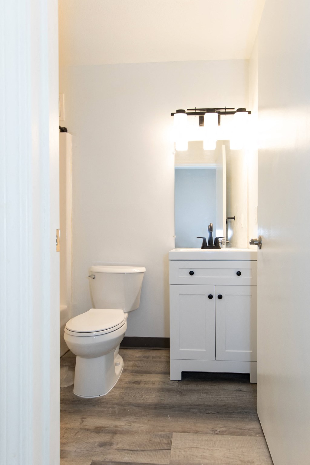 a white bathroom with a toilet and a sink