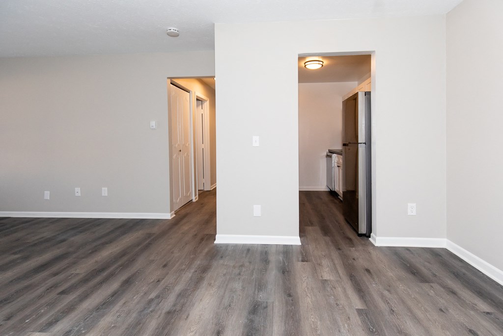 an empty living room with white walls and wood flooring
