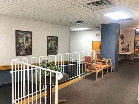 A white railing with a table and chairs in front of it.