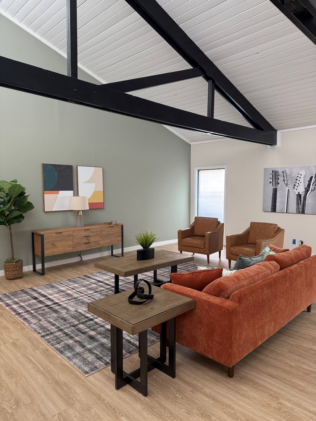 Lounge room with a red couch, a wooden coffee table, and a wooden bench. at Commons At Waters Edge, Columbus Ohio