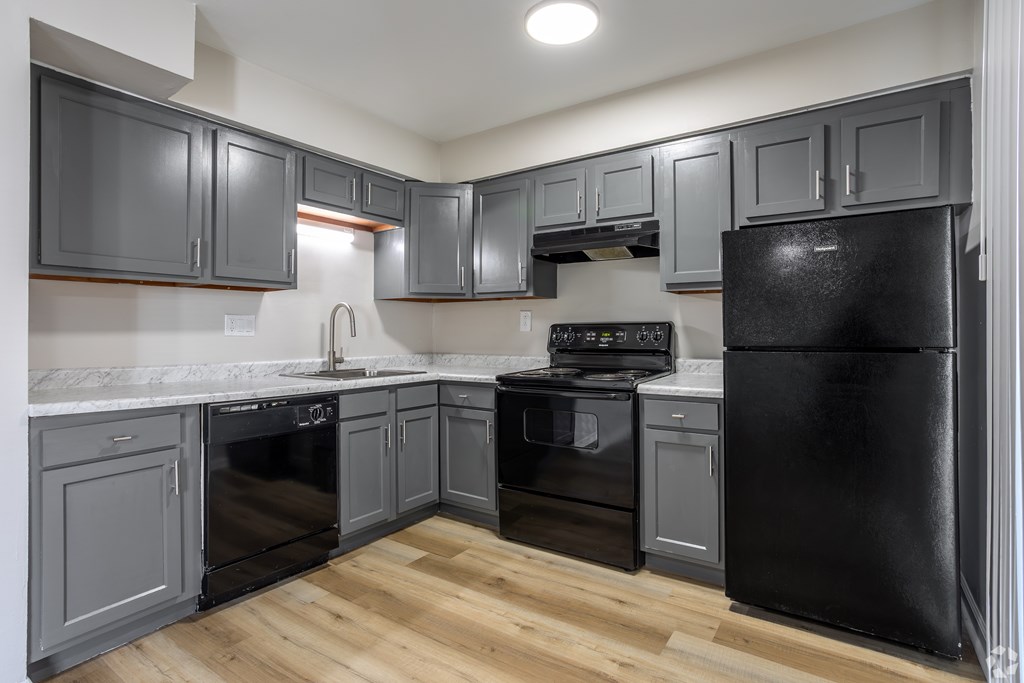 A kitchen with black appliances and grey cabinets. at Commons At Waters Edge, Columbus Ohio