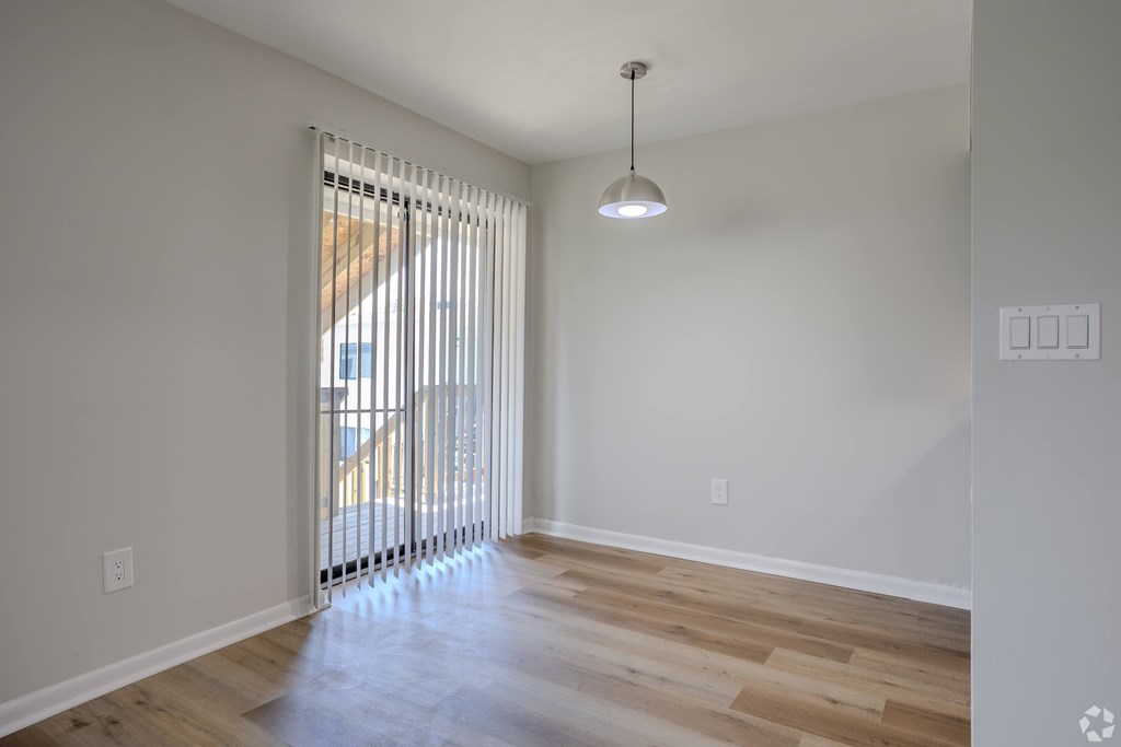 A room with a wooden floor and a window with blinds. at Commons At Waters Edge, Columbus Ohio