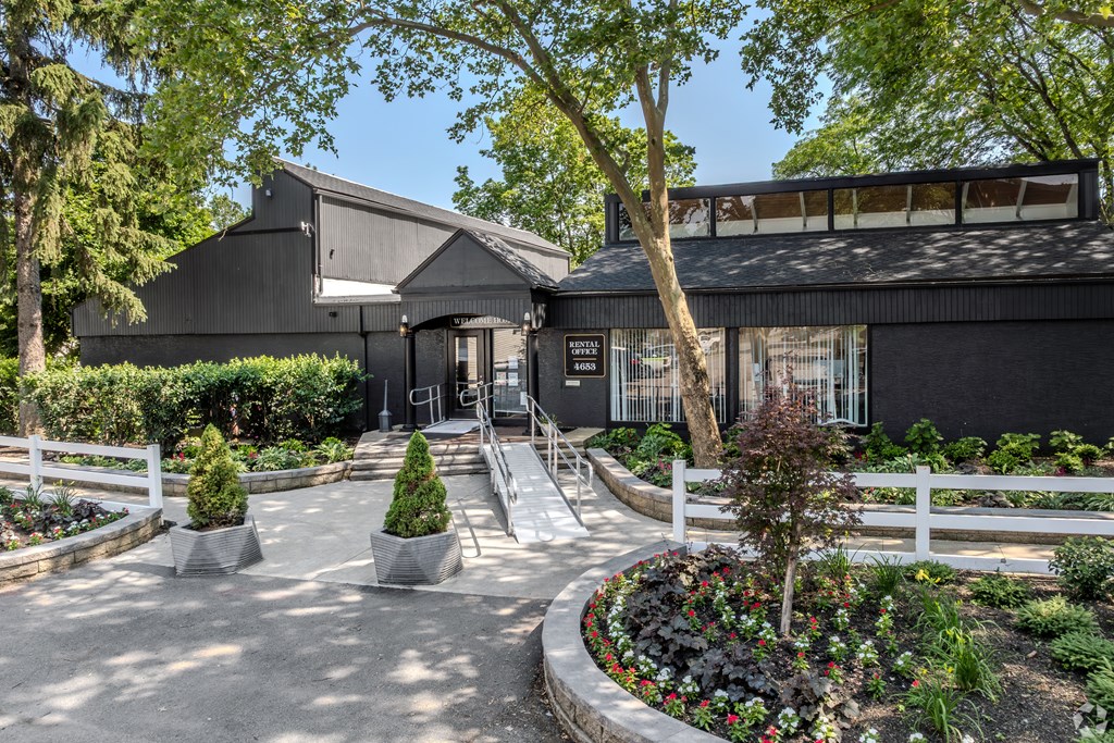 A black building with a white fence and a garden in front. at Commons At Waters Edge, Columbus Ohio