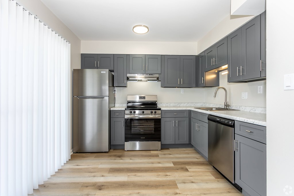 A modern kitchen with wooden floors and stainless steel appliances. at Commons At Waters Edge, Columbus Ohio