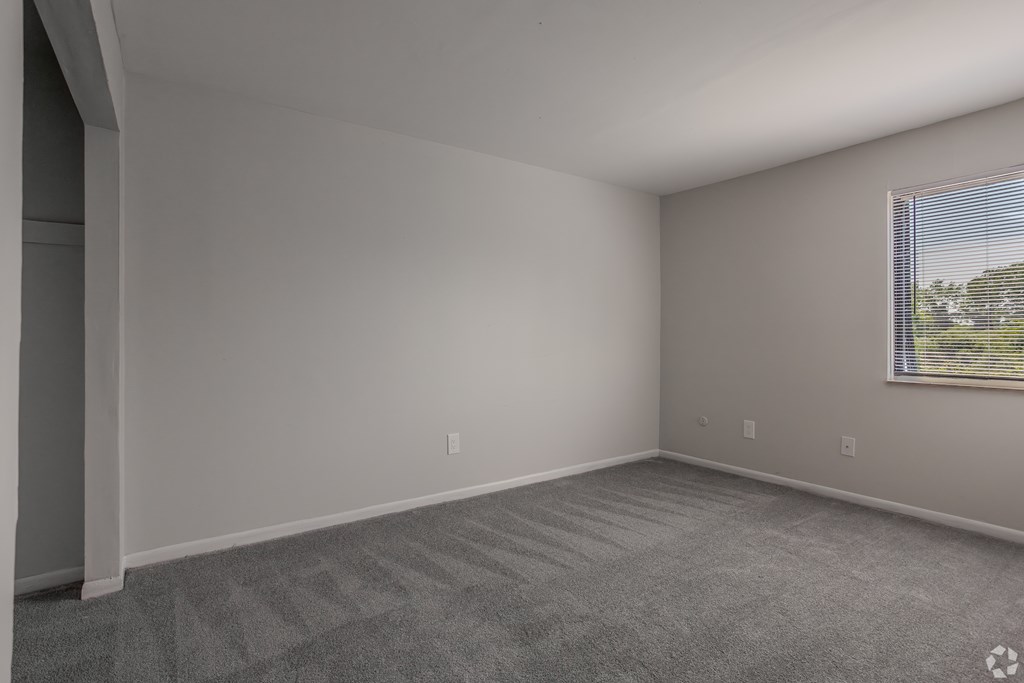 A room with a carpeted floor and a window with blinds at Commons At Waters Edge, Columbus Ohio