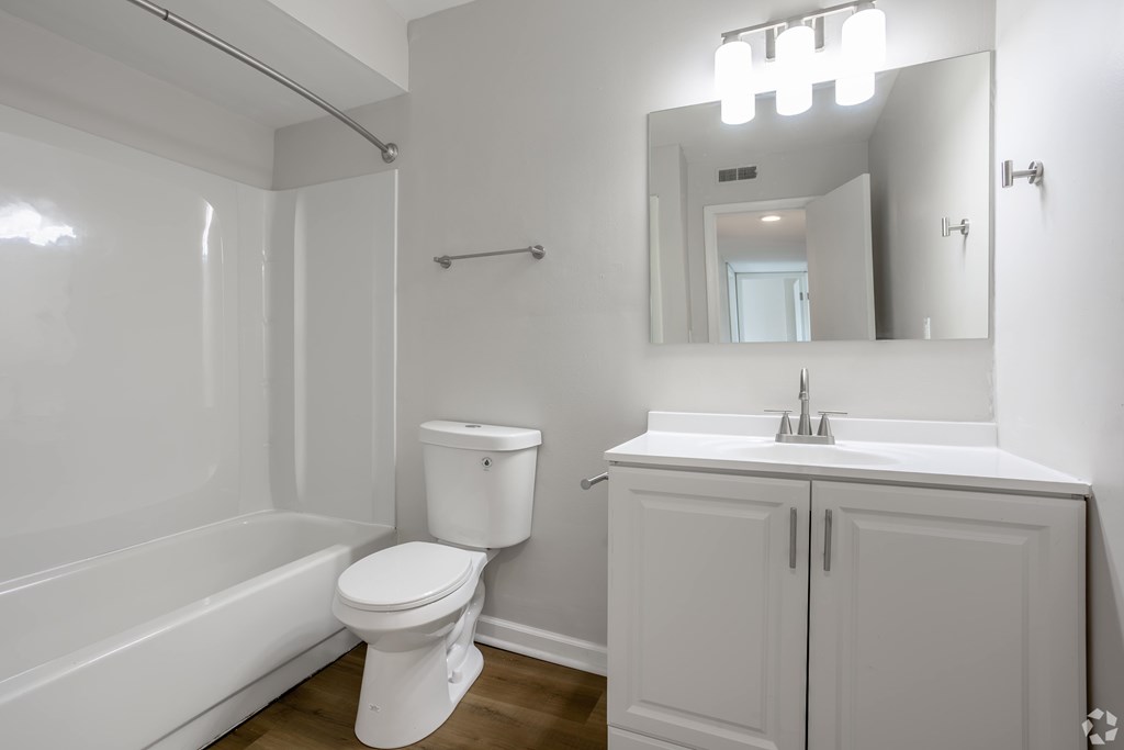 A white bathroom with a toilet, sink, and bathtub. at Commons At Waters Edge, Columbus Ohio