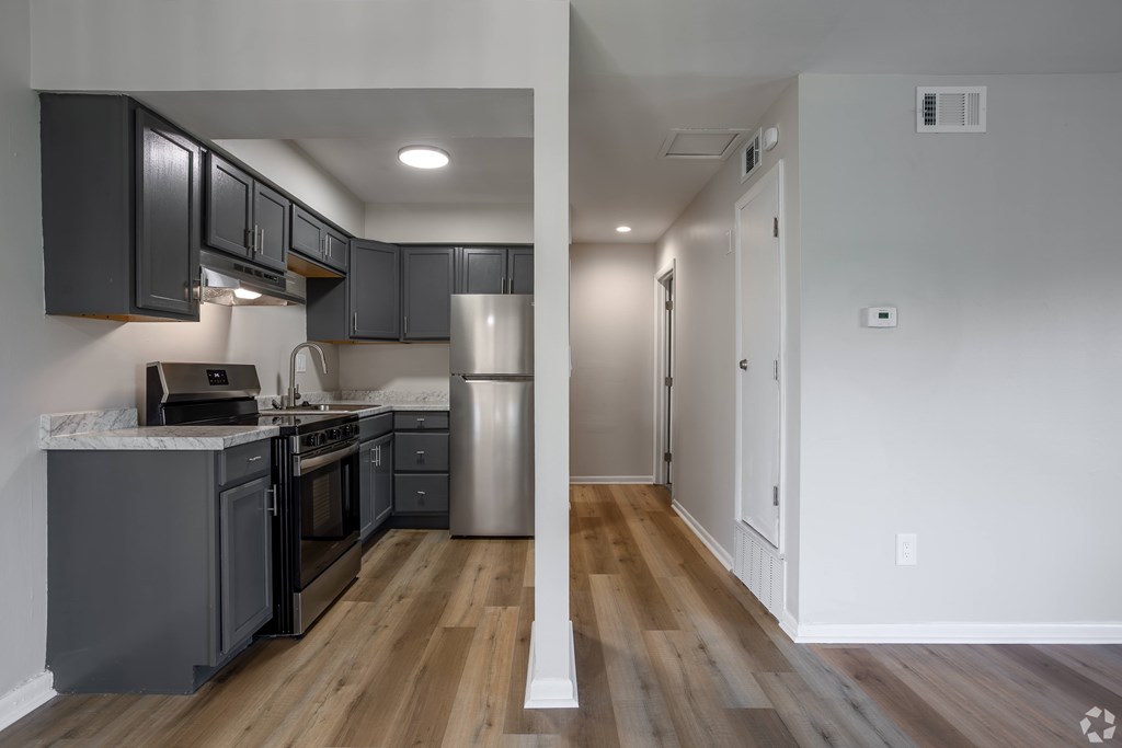 A kitchen with dark wood cabinets and a white countertop. at Commons At Waters Edge, Columbus Ohio