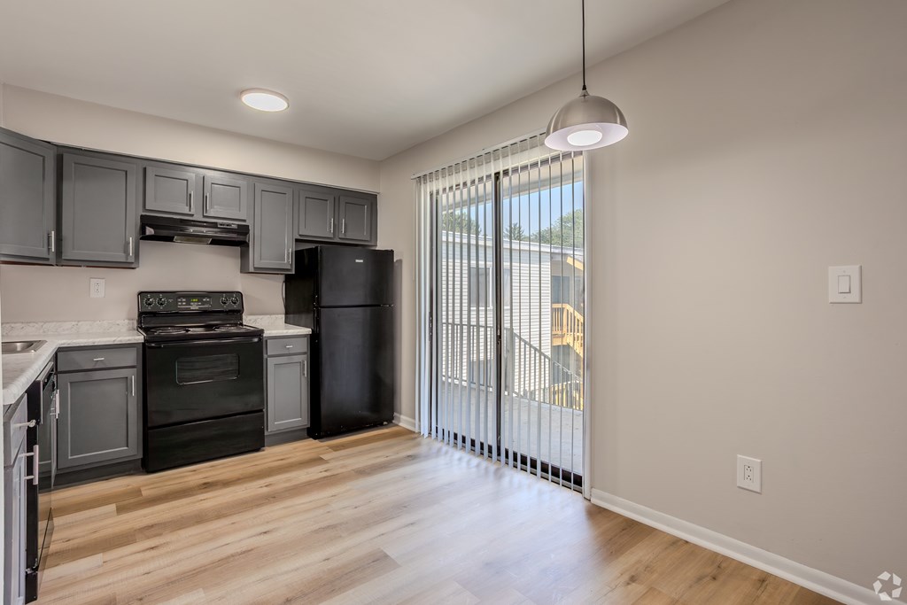 A kitchen with black appliances and wooden floors. at Commons At Waters Edge, Columbus Ohio