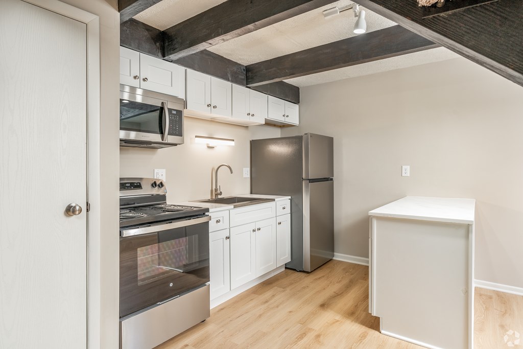 A kitchen with white cabinets and a stainless steel oven.