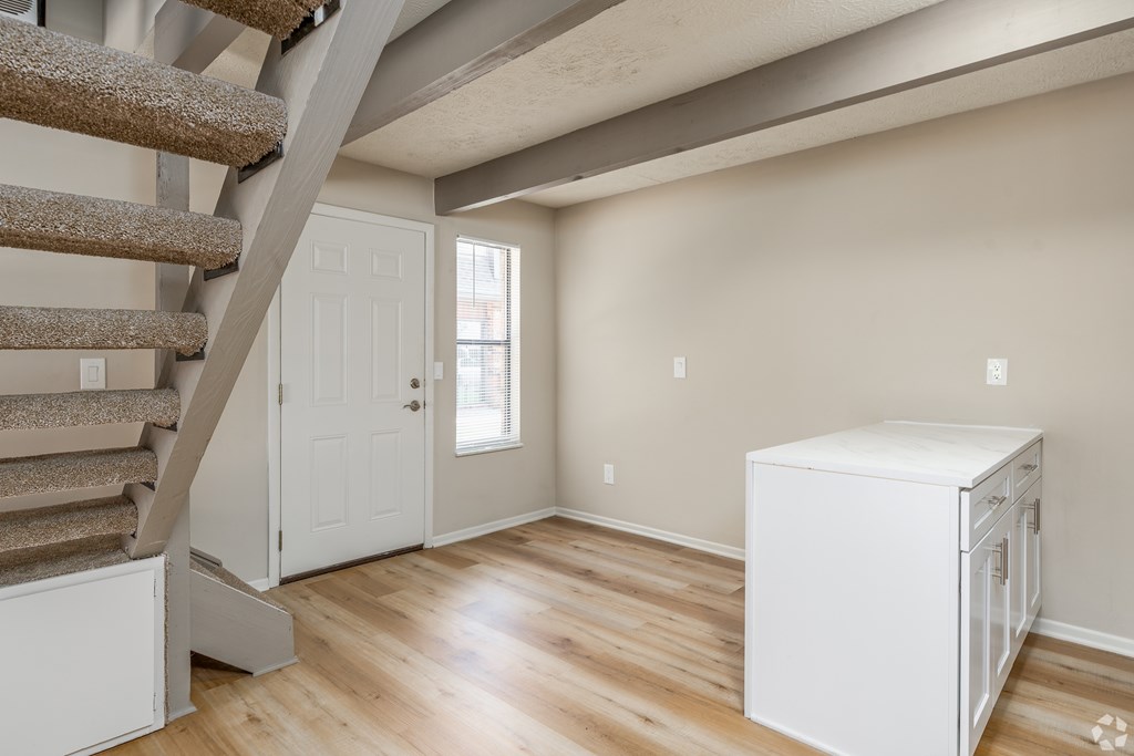 A room with a staircase and a white cabinet.