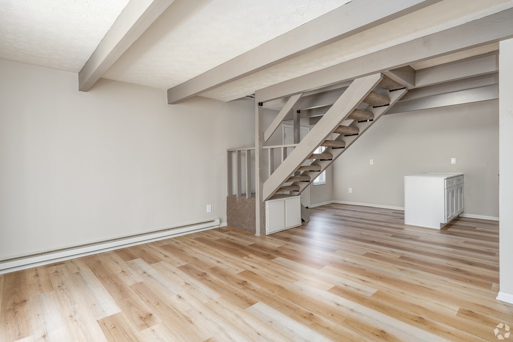 A room with wooden floors and a staircase.